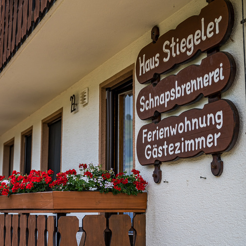 Holzschilder an der Hausfassade mit der Beschriftung Haus Stiegeler, Schnapsbrennerei und Ferienwohnung, Gästezimmer - Holzschilder an der Hausfassade mit der Beschriftung Haus Stiegeler, Schnapsbrennerei und Ferienwohnung, Gästezimmer -